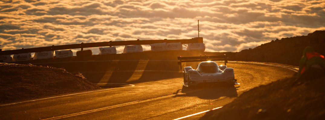 Volkswagen I.D. R Pikes Peak exterior shot climbing the peak with a sea of clouds and setting sun in the background