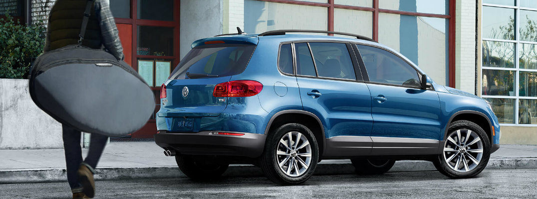 2018 Volkswagen Tiguan Limited exterior shot blue paint job parked next to a sushi restaurant as driver walks towards it