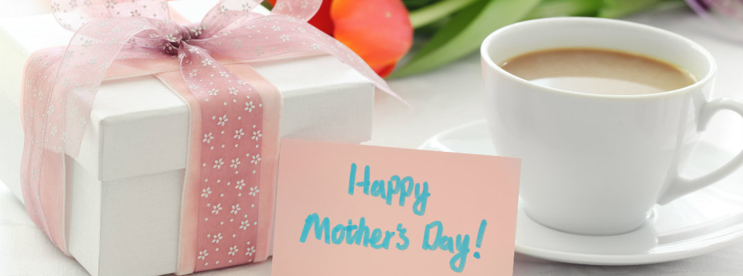 happy mother's day card next to a cup of coffee, a bouquet of flowers, and a wrapped gift