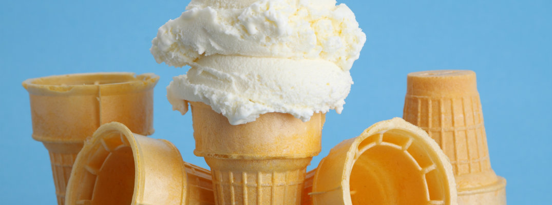 vanilla double scoop ice cream wafer cake cone with a few empty cones near it