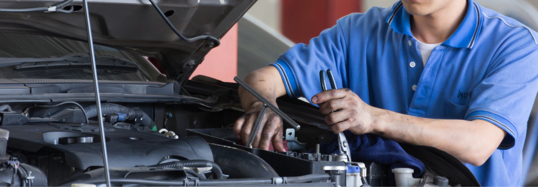 Mechanic working under hood of a vehicle