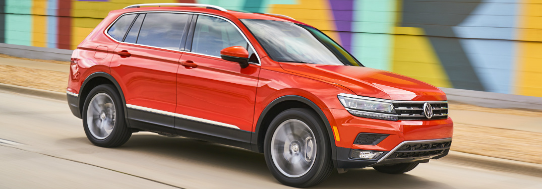 Orange 2018 VW Tiguan Driving by a Colorful Wall