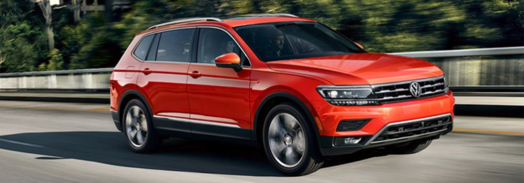 Orange 2018 VW Tiguan Driving by a Forest