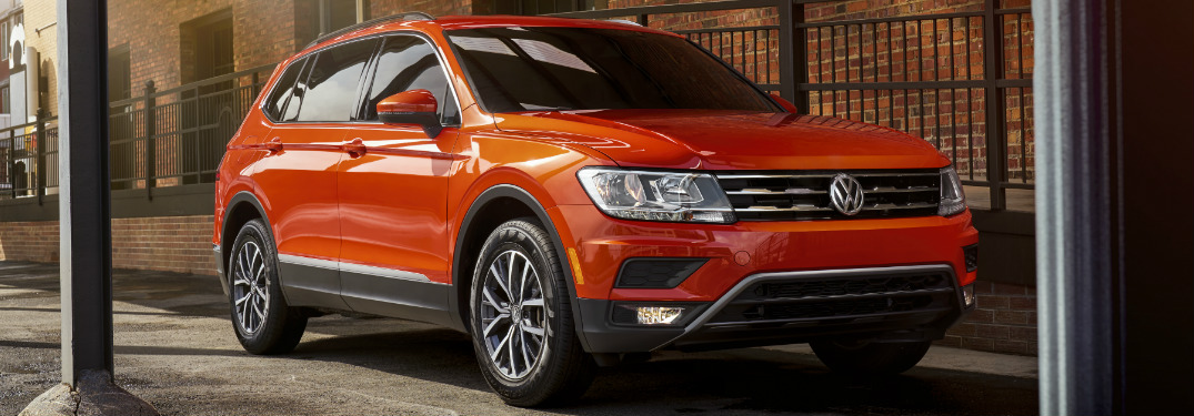 Orange 2018 VW Tiguan Parked next to a Brick Building