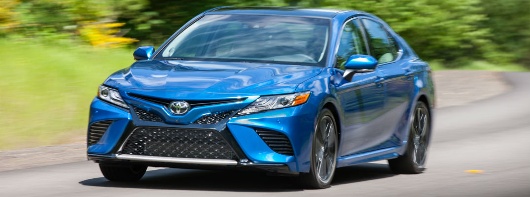 A front view of a blue 2018 Toyota Camry coming down the road