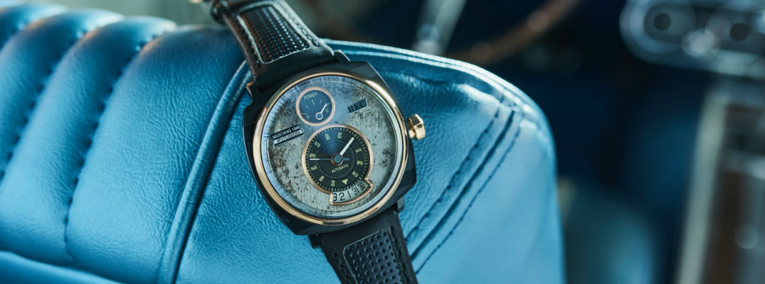 A photo of a Mustang watch displayed on the back of a Mustang's front seat