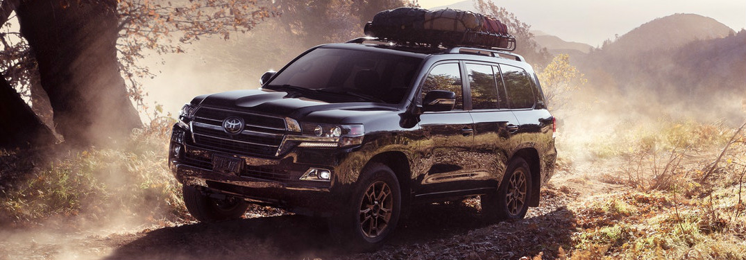 Black 2020 Toyota Land Cruiser driving on a dusty trail