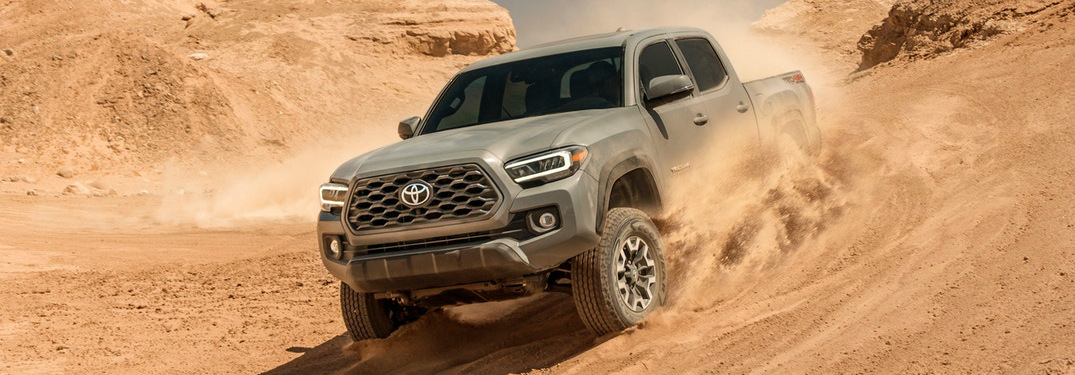 Grey 2020 Toyota Tacoma driving down a sand dune