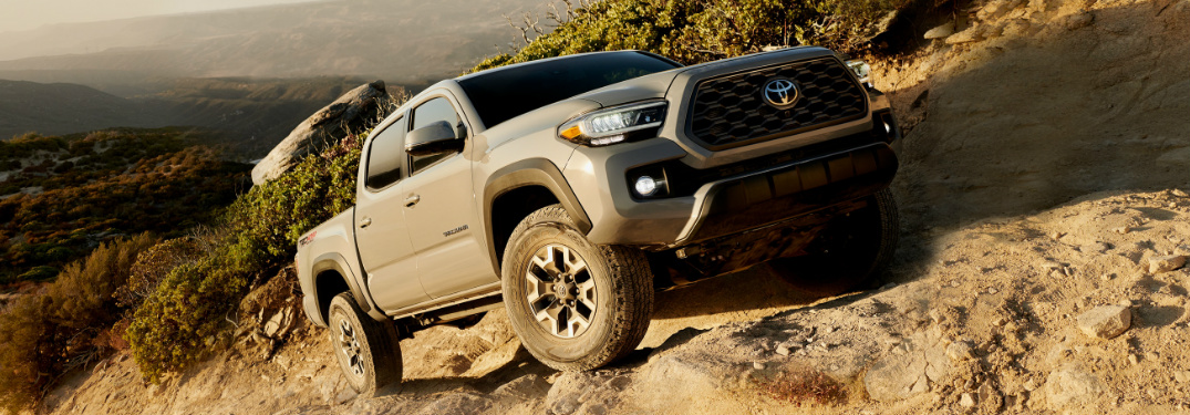 Grey 2020 Toyota Tacoma driving up a rocky hill