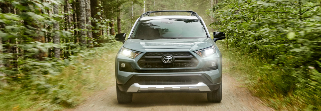Light blue 2020 Toyota RAV4 driving on a forest road