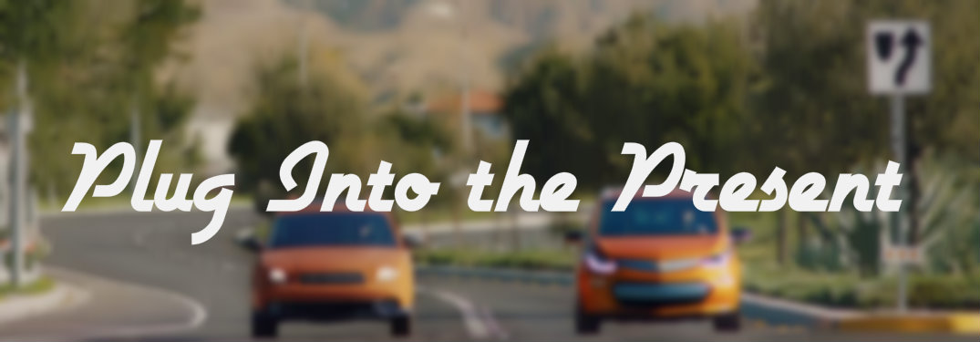 Plug Into the Present text over blurred picture of orange cars