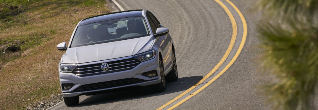 white vw jetta driving on rural road