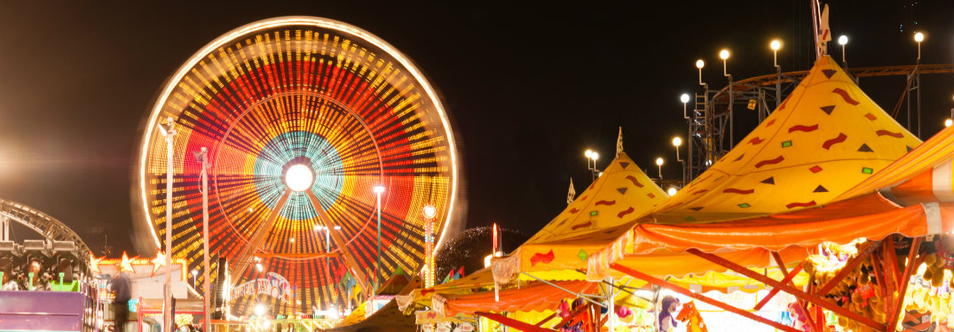 Ferris wheel and carnival tents at night