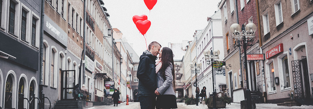couple in a city with heart balloons