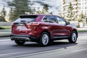 side view of a red 2019 Ford Edge driving on a city road