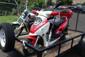 a motorcycle and a scooter on a trailer