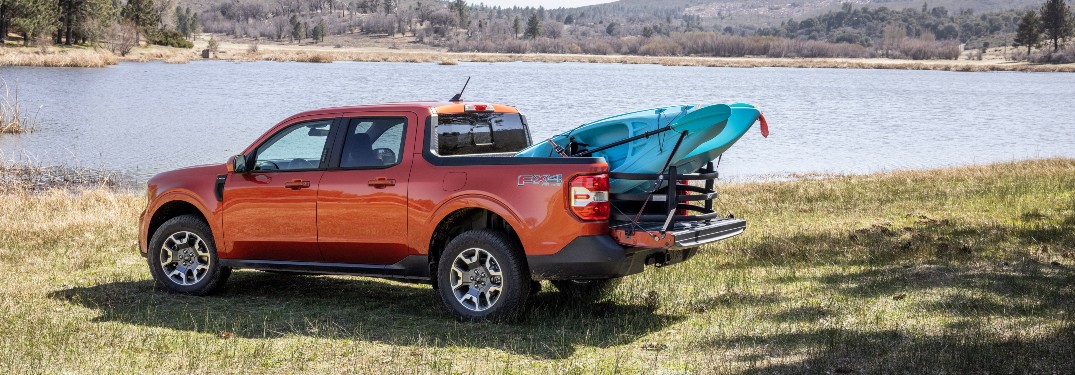 side view of a red 2022 Ford Maverick hauling a kayak