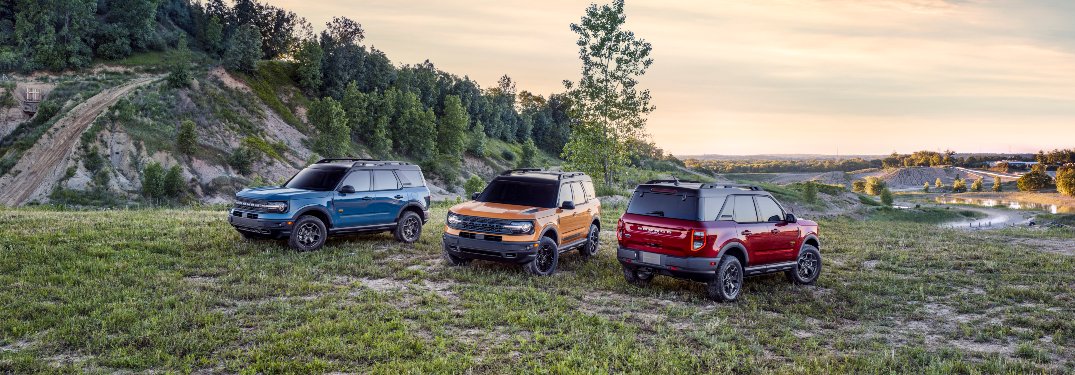 a trio of 2021 Ford Bronco SUVs on a grassy hill