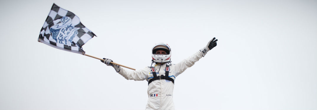 Racecar driver Romain Dumas holding the checkered flag