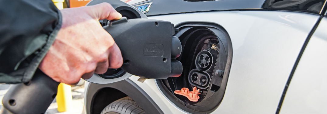 hand plugging cable into 2018 and 2019 chevrolet bolt ev
