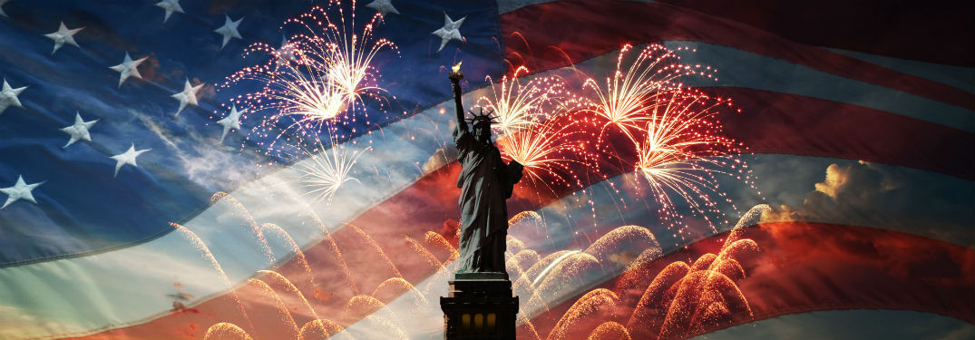 statue of liberty standing in front of fireworks and american flag