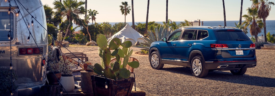 2021 Volkswagen Atlas SEL exterior shot with dark blue paint color parked by a trailer on the beach