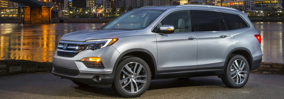 silver 2018 Honda Pilot parked outside downtown area with skyscrapers in background