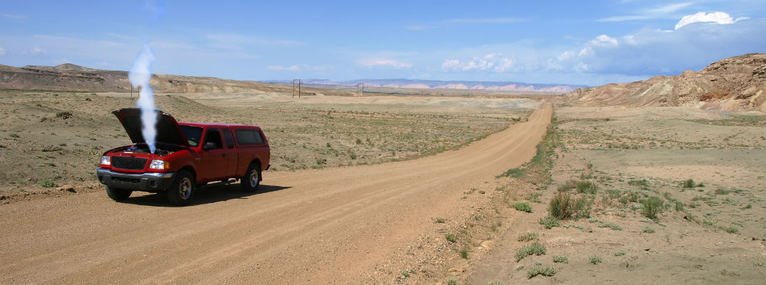 A stock photo of a vehicle overheating in the middle of nowhere.