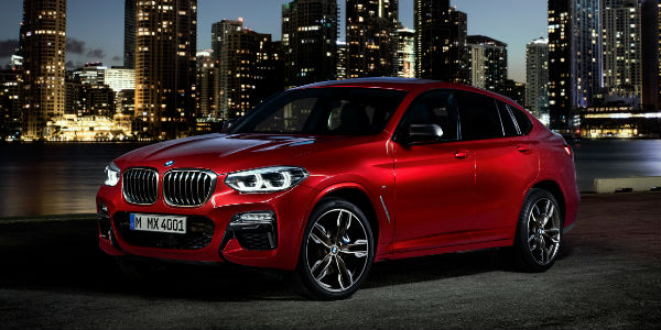 Red 2019 BMW X4 Front Exterior at Night with City Skyline in the Background