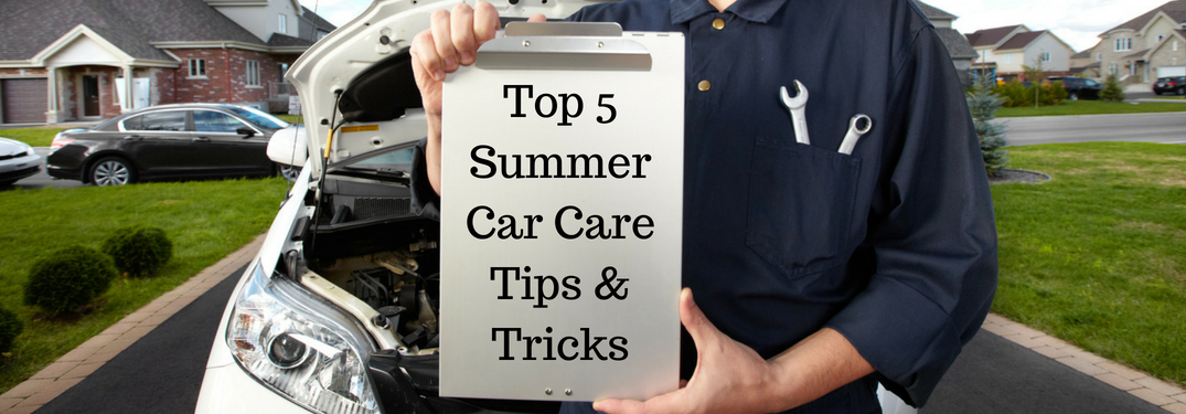 Mechanic in Blue in Front of a White Car Holding a Clipboard with Black Top 5 Summer Car Care Tips & Tricks Text