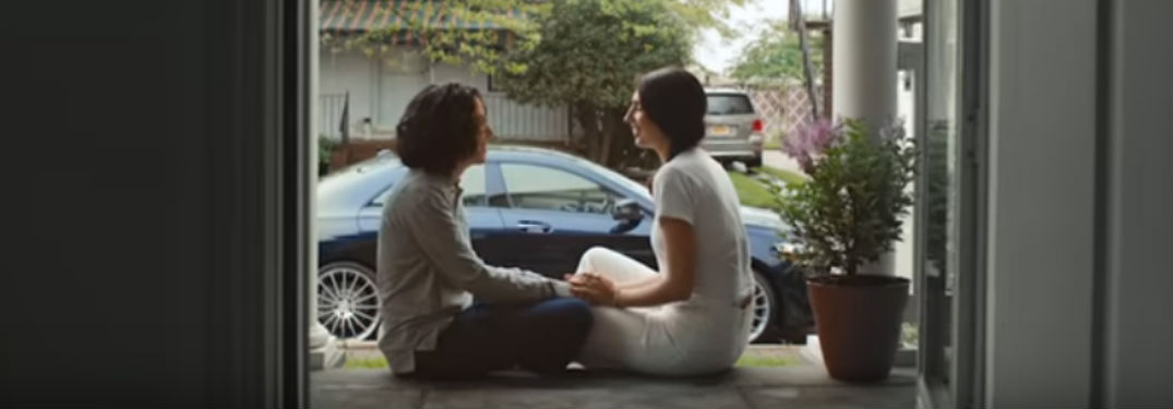 Two women sitting on the front porch of a house