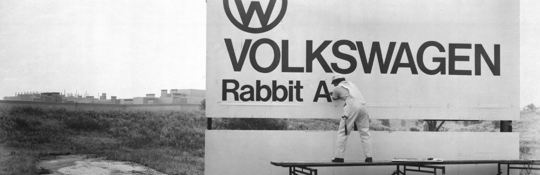 retro photo of a man painting a sign for Volkswagen