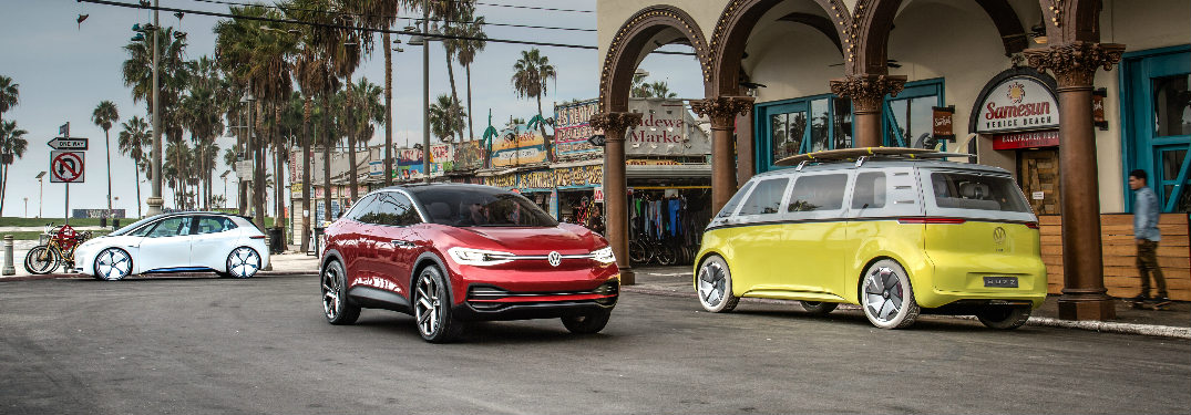 Three Volkswagen I.D. concept vehicles parked in a beach side town