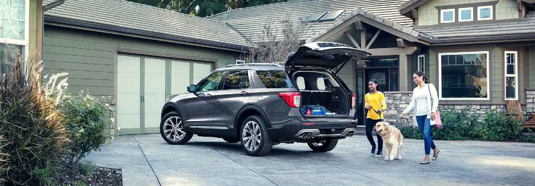 Mother, daughter and dog waling behind 2021 Ford Escape with gate ajar