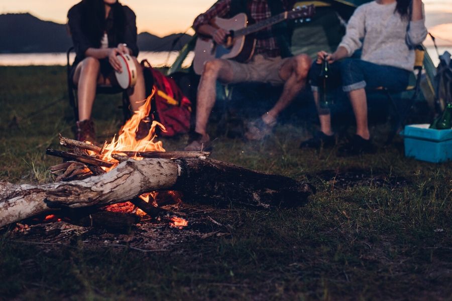 Crew sitting by fire camping