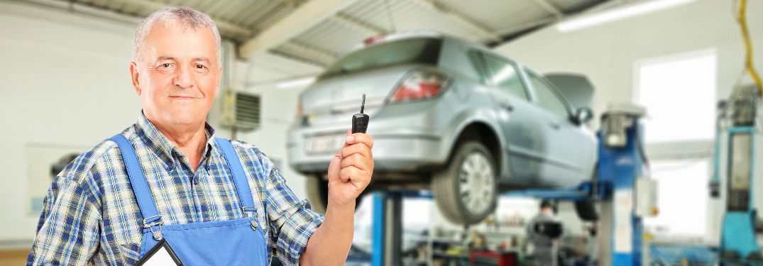 Service professional standing holding a key at a service center