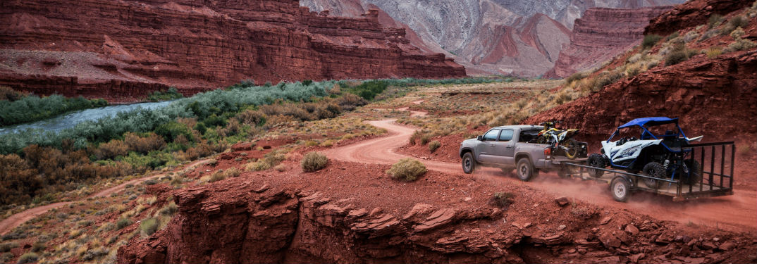 2018 Toyota Tacoma Engine Options and Specs with image of 2018 Tacoma TRD Off-Road towing trailer through a desert canyon
