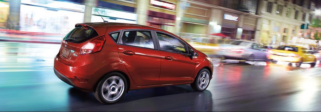 2018 Ford Fiesta in red driving in the city