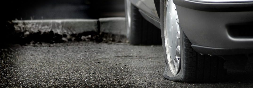 image of a flat tire parked in a lot