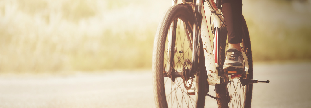 lower portion of woman biking on cement trail