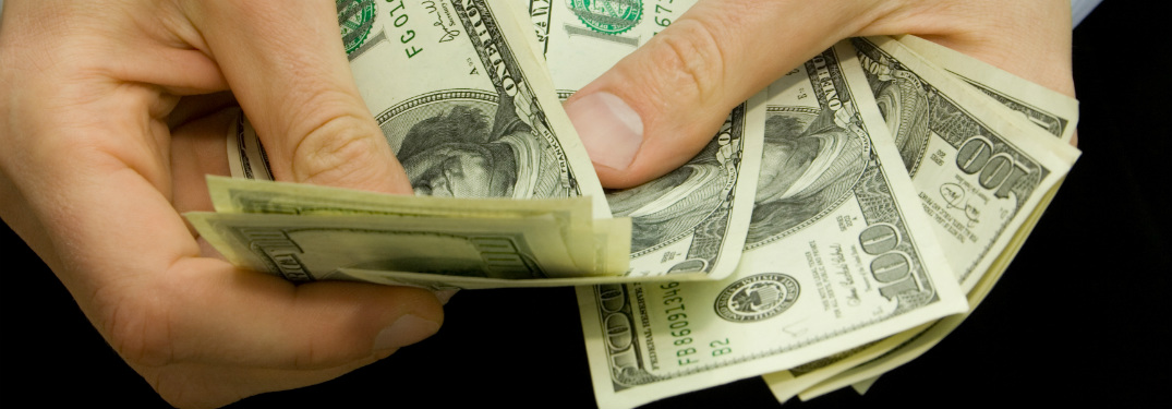 man holding hundred dollar bills cash