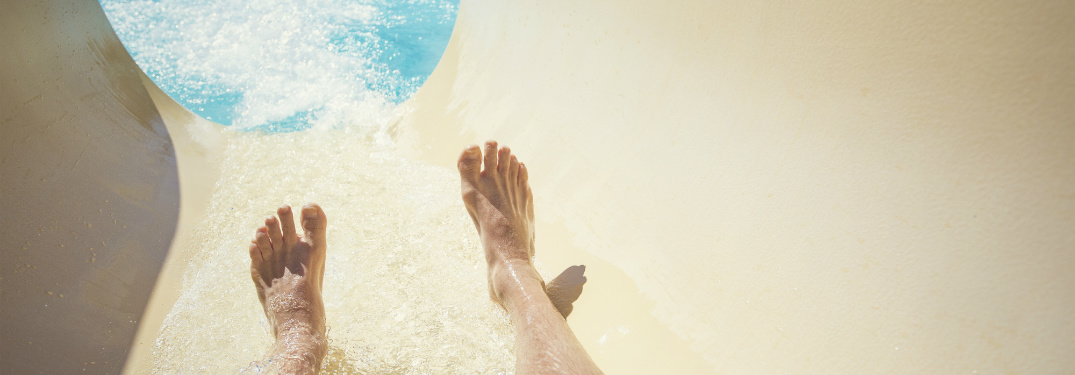 POV view of man sliding down waterslide into pool