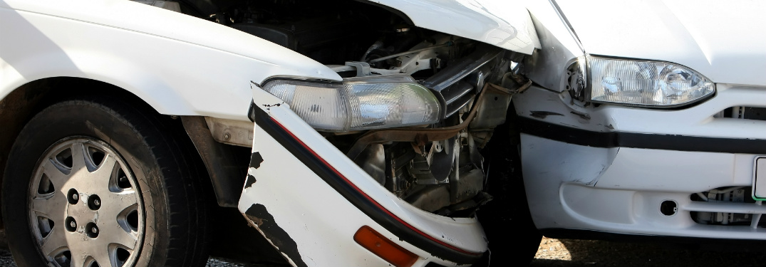 close up of front ends of two cars after colliding in accident