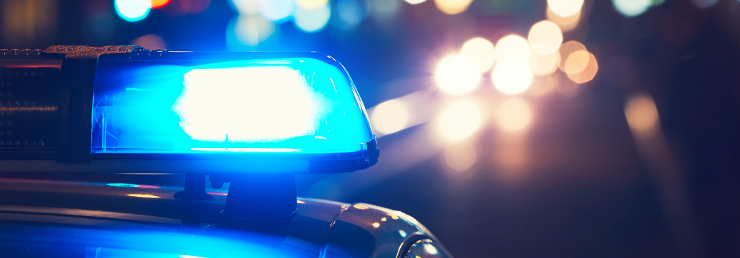 flashing blue light on cop car at night in city