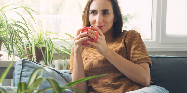 Woman holding mug and sitting on couch