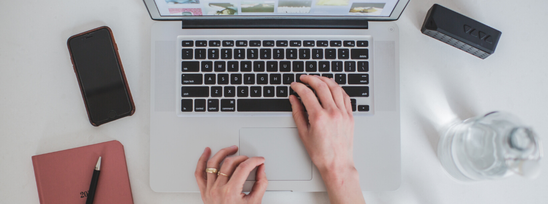 Overhead view of hands on laptop keyboard