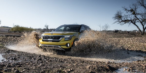 Yellow 2021 Kia Seltos driving through mud