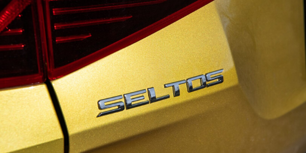 Closeup of badge on yellow 2021 Kia Seltos