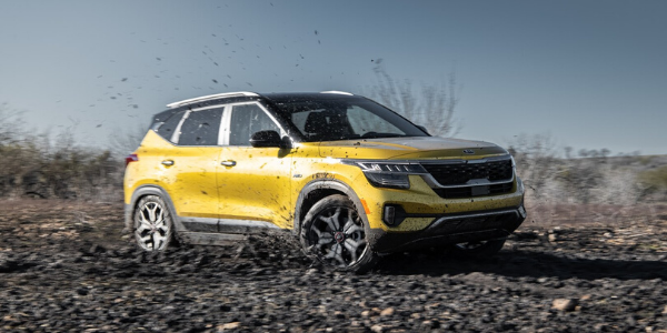 Yellow 2021 Kia Seltos driving through mud