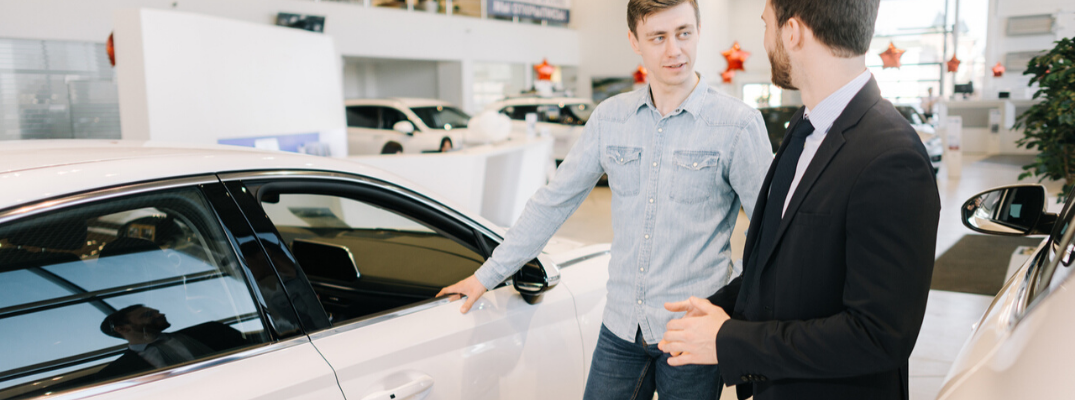 Salesman showing customer a car